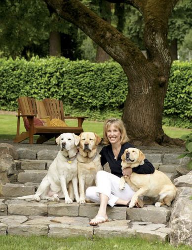 Liz Williams relaxes with beloved yellow Labrador Retrievers (left to right) Riley, Higgins, and Mimi. Behind them is the playfield used by the three Williams children, and it borders the expanding vegetable garden where Nick Williams relaxes after work.