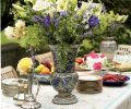 Collections of vases and china are showcased when Liz Williams entertains. The flower arrangement contains Asiatic lilies, Calla lilies, roses, catmint, and lady’s mantle, all from the garden.