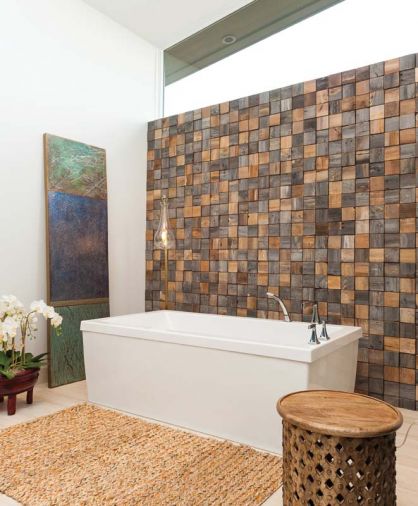 Ewan created a custom tile accent wall for the bathroom from reclaimed barn wood recycled into square tiles that are set randomly, with horizontal and vertical grain. “The tiles are not absolutely flush,” says Ewan, “so it brings in some of that rustic element and avoids feeling stark or cold, but it still doesn’t overpower the modern aesthetic.”
