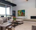 A custom gas fireplace brings a horizontal element into the living room. Encased in simple white porcelain tile in a linear grid form typical of mid-century style, it provides a commanding centerpiece yet retains a light, simple look.