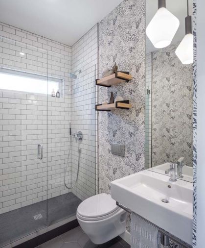 A wall mount sink and toilet with in-wall carrier system helped to maximize the limited space in this new main level full bath, which replaced an original powder bath in poor shape. The field tile in the shower is from Dal Tile. The floor tile is Straturra Hex from Ann Sacks.