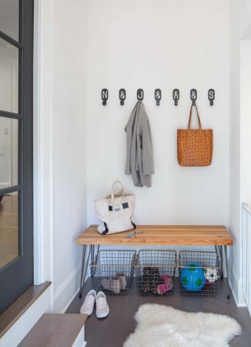 A mudroom located near the backyard entrance from the detached garage features a custom bench by Tretiak Works fashioned from fir recycled from the home.