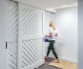 A custom basement utility door designed in collaboration with Birdsmouth lets in light and encourages airflow.
