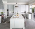 One of the homeowners is a serious home cook, so designing a beautiful, functional kitchen for family and entertaining was a major focus of the design process. “The goal was to make the kitchen super functional but still have visual balance,” explains Baines. “We tried to create as much symmetry in the space as we could, and create a geometric rhythm that moves around the space.” Mostly neutral colors are accented by whimsical bright red knobs on the professional-grade range.