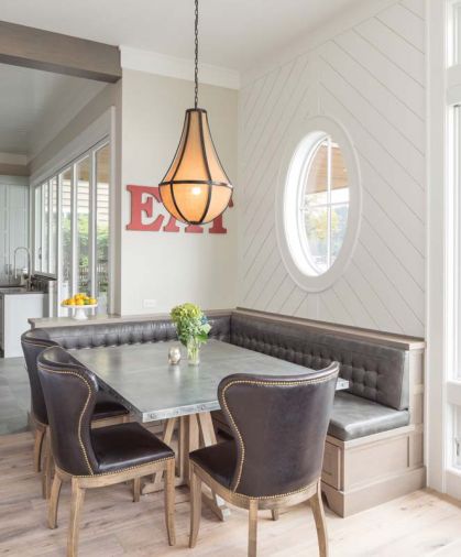 A combination of different leather finishes on chairs and built-in benches provides subtle visual interest at the dining nook.