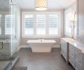 The herringbone motif from the dining room and breakfast nook is carried into the master bathroom, but here, it’s found on the floor rather than the wall. Symmetrical design principles carry through even to the more functional components of the home, like the shower and storage areas.