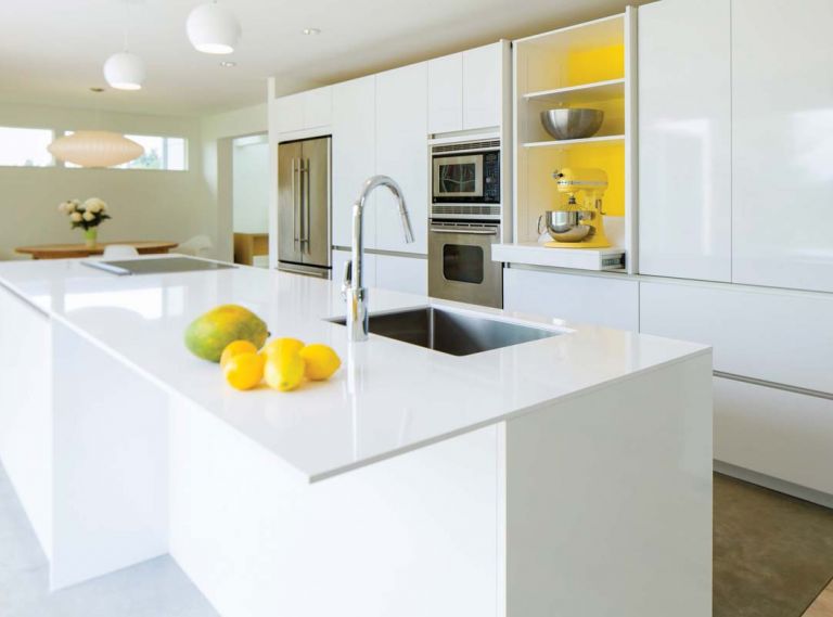 Homeowner Michaela Spaeth wanted to see a “happy” yellow color inside the central cabinet, and SieMatic had just introduced a signature yellow lacquer accent color that matches her KitchenAid perfectly.