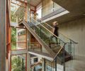 Three stories of living space are linked with a steel and concrete staircase illuminated by a custom LED light fixture made from hand-cast glass globes. “It’s so beautiful at night,” says McClellan. “You can see the light fixture from the entry door, and it reflects in the windows and the glass railing so it appears there are about three times more lights than there really are.”