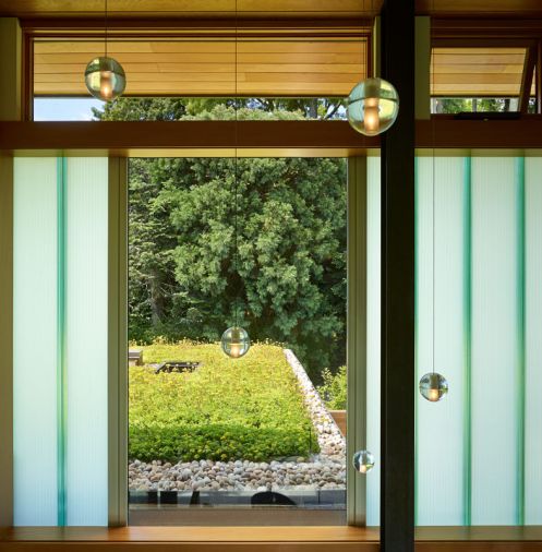 channel glass (more commonly used in institutional buildings) adds drama to the entrance as it wraps across the second story and acts as light fixtures between sections of the garden wall.