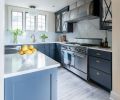 The combination of navy cabinetry with white countertops and tile gives a crisp, tailored look. Because the family cooks frequently, Heather opted for a durable quartz product for the countertops and oven backsplash, finished to resemble Calcutta marble.