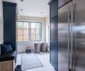 As part of the kitchen remodel, Heather created a custom bench and installed new cabinetry in the entryway, transforming it into a functional mudroom—essential for a family with young children. Porcelain tiles conceal an underfloor radiant heat system, but look like wide-plank wood.