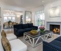 Navy blue sofas ground the light-filled formal living room that is walled by French doors.