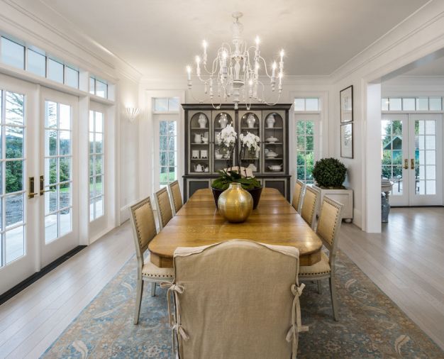 An oak dining table that belonged to the homeowner’s grandmother gives the home a sense of history and provides seating for up to ten. Colors in the area rug carry through on the blue tones seen throughout the home. Far wall was designed to accommodate the couple’s existing china cabinet. 