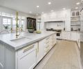 A Blue Star custom range from Eastbank Contractor Appliances takes center stage. Subway tile, Carrara marble, and classic cabinets combine with stainless steel appliances and brass hardware in a twist on tradition. A spacious island forms the kitchen’s epicenter.