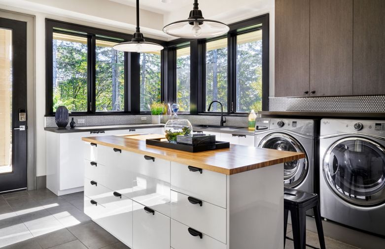 Multi-use counterspace can be used for folding laundry/crafts. Stools tuck beneath the lip when not in use. Industrial hood pendants by Rejuvenation, retro penny tile backsplash with dark grout adds punch.