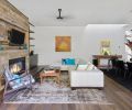 Natural materials soften the contemporary look of the living area: reclaimed wood, an antique style wool rug, leather couch and a 15th-century Ming Dynasty wood table. Tinted mirrors behind the shelving add depth and warmth.