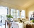 A small balcony off the living room makes it easy to enjoy the lake, mountain, and city views. Horizontal boards on the walls and ceiling give the home a clean, almost beach-y feeling.