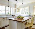 Built for cooking and entertaining, the kitchen includes a deep farmhouse sink, two ovens, and an inviting island where friends and family can watch the action. Rather than inset can lighting, Sara chose a collection of pendant lights to maintain the vintage feel. To the right, a kitchen desk makes the perfect perch for a computer, tablet, or cookbook.