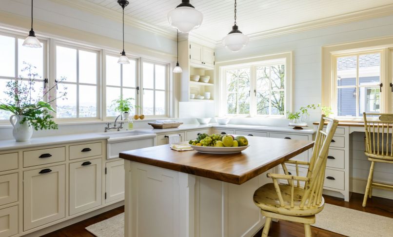 Built for cooking and entertaining, the kitchen includes a deep farmhouse sink, two ovens, and an inviting island where friends and family can watch the action. Rather than inset can lighting, Sara chose a collection of pendant lights to maintain the vintage feel. To the right, a kitchen desk makes the perfect perch for a computer, tablet, or cookbook.