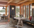 This cabin on the shores of San Juan Island invites the outdoors in at every turn. The same variegated blue stone used for the patio also forms the floor of the main entry room, creating a sense of continuity and cohesion. A built-in bench around two sides of the dining table keeps the small space streamlined, while the bank of windows in the corner provides an immediate connection to the shoreline just outside.