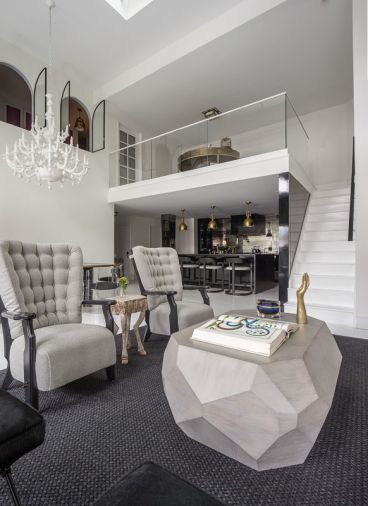 Inspired by a vintage 1940s  stone coffee table, Howe  designed this multi-faceted oak coffee table with pale gray stain. “I wanted something sturdy and durable,” she says. The black wool sisal blend rug was a practical choice to accommodate the client’s two dogs.