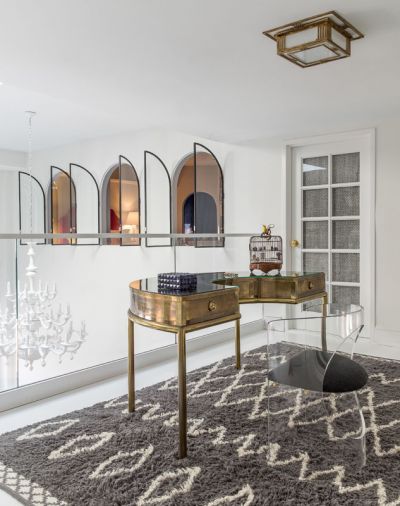 A 1970s Italian brass desk occupies the balcony, where a staircase to the rooftop was originally 
envisioned to reside. A West Elm rug, and Visual Comfort brass light fixture were temporary.