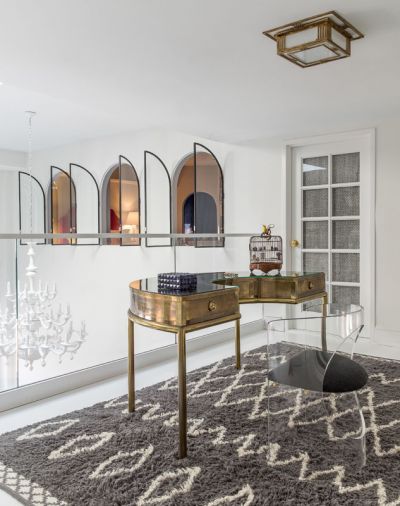 A 1970s Italian brass desk occupies the balcony, where a staircase to the rooftop was originally 
envisioned to reside. A West Elm rug, and Visual Comfort brass light fixture were temporary.