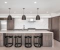 Veneer-clad cabinets and Haleigh Wire Dome Rod pendants from Rejuvenation contrast with the 3-D backsplash by Modular Arts.