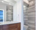 Linear marble tiling from Oregon Tile and Marble gives the bathroom its eye-catching graphic design.
