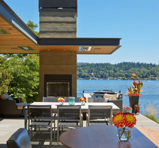 An outdoor fireplace is embedded in a 
custom board form concrete chimney. Built-in lighting and heaters in the overhang make outdoor living comfortable virtually year-round.