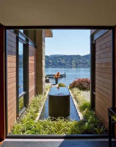 A watercourse and sculpture greets visitors as they enter the home, bringing the water element from the lake right up to the structure.