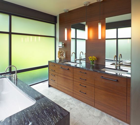 Cabinetry throughout the home is constructed with horizontal-grain wood. “That orientation gives it a more stable feel, more weight,” says Regan. Black marble surrounds the tub.