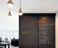 A blackboard finish on the pantry doors provides the perfect place for this busy family to organize their schedule. The open layout and long bank of windows floods the kitchen with light and gives it a warm, inviting feel.