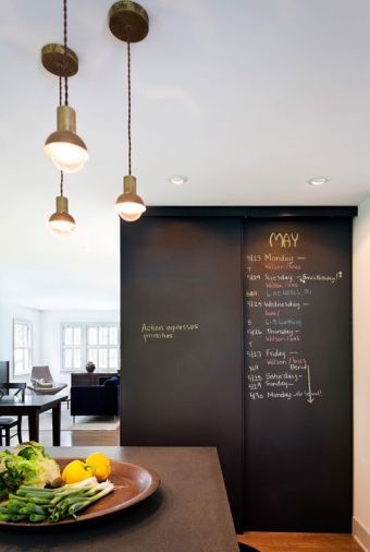 A blackboard finish on the pantry doors provides the perfect place for this busy family to organize their schedule. The open layout and long bank of windows floods the kitchen with light and gives it a warm, inviting feel.