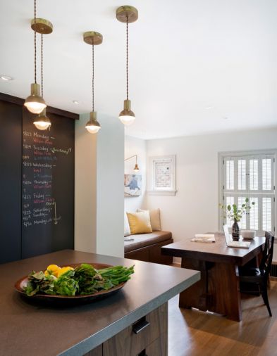 Burnished bronze lighting with exposed cords echoes the warm industrial feel of the concrete countertops.