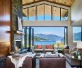 Panels of walnut hide the television; a reclaimed Juniper mantel adds panache to the rock fireplace from Lisac’s Fireplaces & Stoves. Kolbe Doors and black aluminum Marlan windows from Portland Millwork.