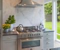 Adding a marble accent wall behind the oven and range brings texture and interest to the kitchen. Jill says this was one area where a little bit of extra spending produced an outsized impact in terms of design.