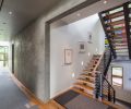 The open tread staircase gives the appearance of suspension in space, with subtle nods to Asian architectural traditions.