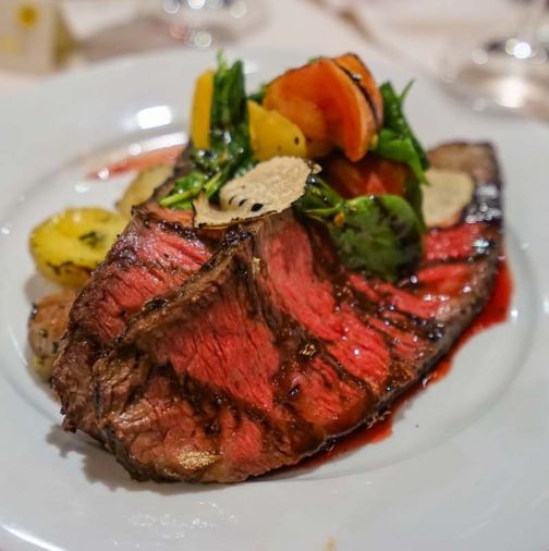 Chef Tyler Krost's grilled Snake River Farm Zabuton - American Kobe Beef Chuck topped with black summer truffles, heirloom tomato salad, and roasted potatoes.