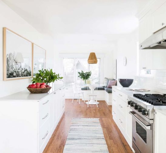 No appliances were moved during the kitchen remodel, but new custom cabinets, PentalQuartz countertops, and a revamped dining nook totally transformed the space. “The original kitchen was broken up with a bunch of different colors,” says Heidi, “and there was nothing in the back corner.” The wooden pendant light above the kitchen table is from Selamat Lighting, and echoes the warm tones of the wood floor.