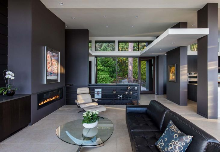 Staircase from the lower level and attached garage faces the kitchen, carrying through the same Raven Caesarstone ledge at left as is found on the kitchen island countertop ahead.