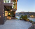 Existing boulder outcroppings become part of the landscape as they rise out of the concrete patio. The office juts out from the mudroom at left with guest bedroom and media room beyond.