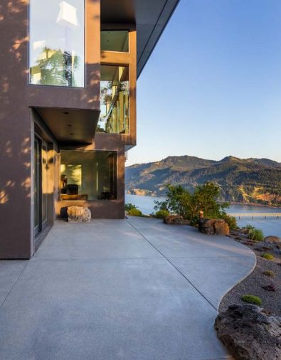 Existing boulder outcroppings become part of the landscape as they rise out of the concrete patio. The office juts out from the mudroom at left with guest bedroom and media room beyond.