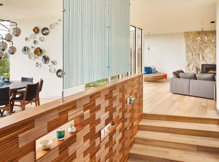 Walnut paneling from DuChateau, 3-Form made the resin paneling which is infused with blue string. Hardwood flooring is also DuChateau. The floating chair is an outdoor piece from Dedon.