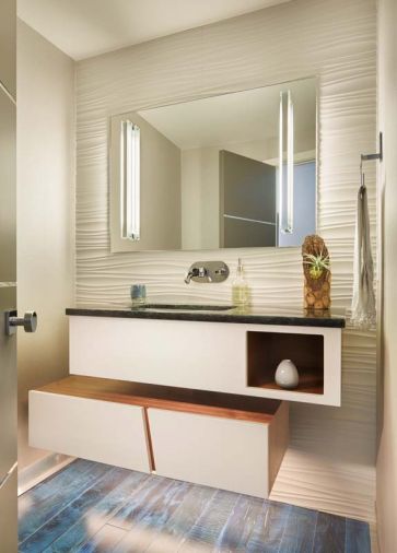 Decker Design installed the lovely blue tile backsplash. The tiles were by Mir Mosaic. Floating walnut shelves add contrast to the blue tones. Book storage was a must for the homeowner, Schoener accommodated with a blue built-in bookshelf. Deep drawers provide ample storage.