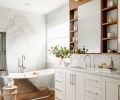 The bookmatched marble makes a stunning backdrop to the Waterworks tub. Robern medicine cabinets bordered by walnut perimeter,