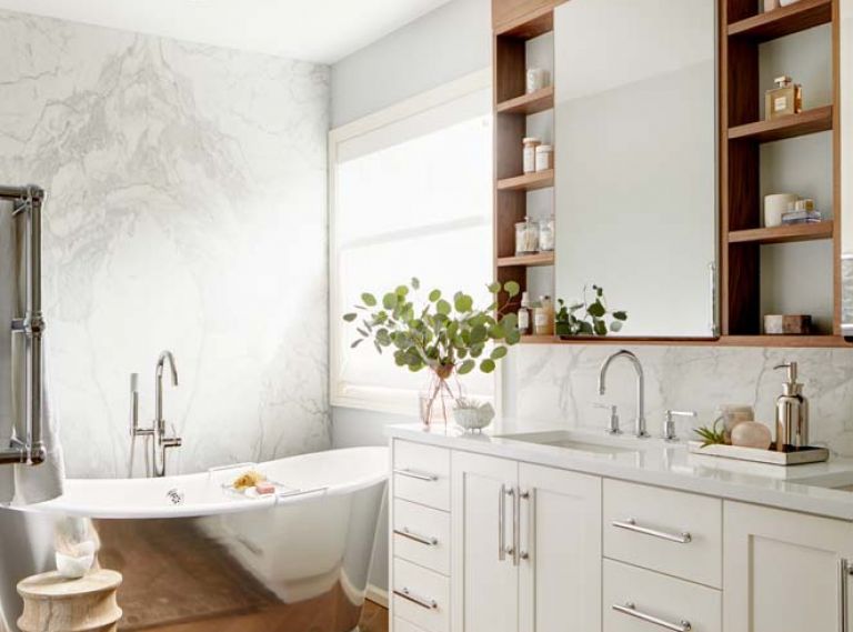 The bookmatched marble makes a stunning backdrop to the Waterworks tub. Robern medicine cabinets bordered by walnut perimeter,