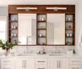 Wall-to-wall for generous storage, with marble wrapped within it. Sinks from Kohler. Vanity sconces by Waterworks.