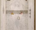 The bookmatched marble echoed in the shower, the shampoo niche extends the entire width of the shower.