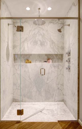 The bookmatched marble echoed in the shower, the shampoo niche extends the entire width of the shower.